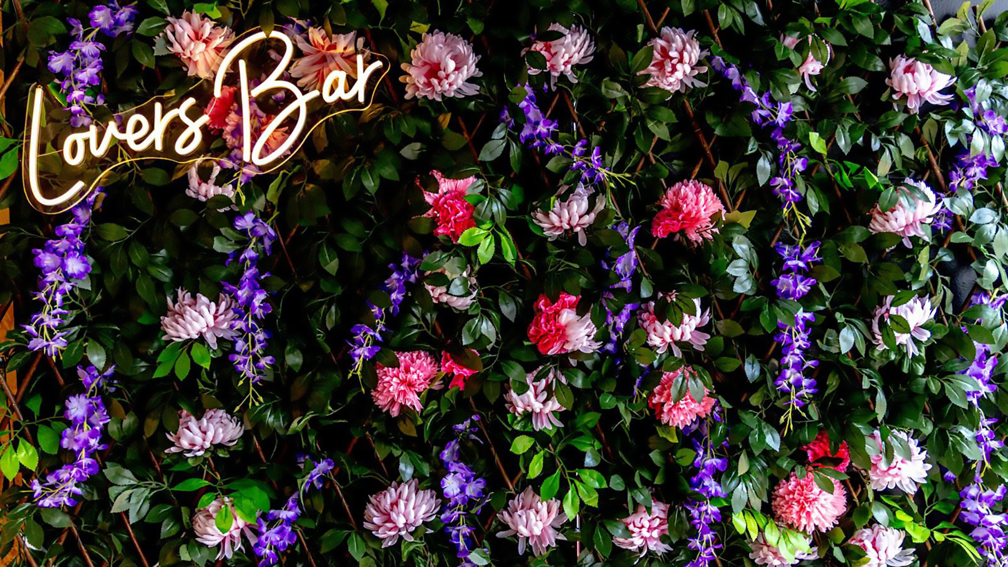 Lovers Bar light up sign on flower wall
